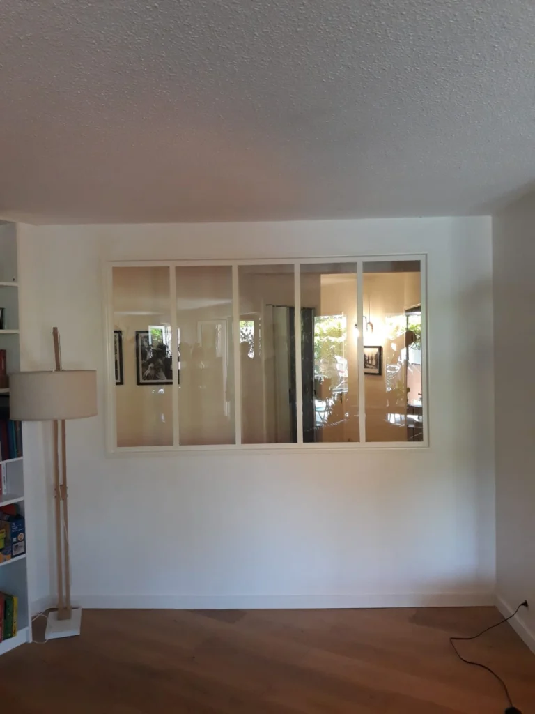 Verrière d’intérieur à cinq vitrages et cadre blanc, dans un salon