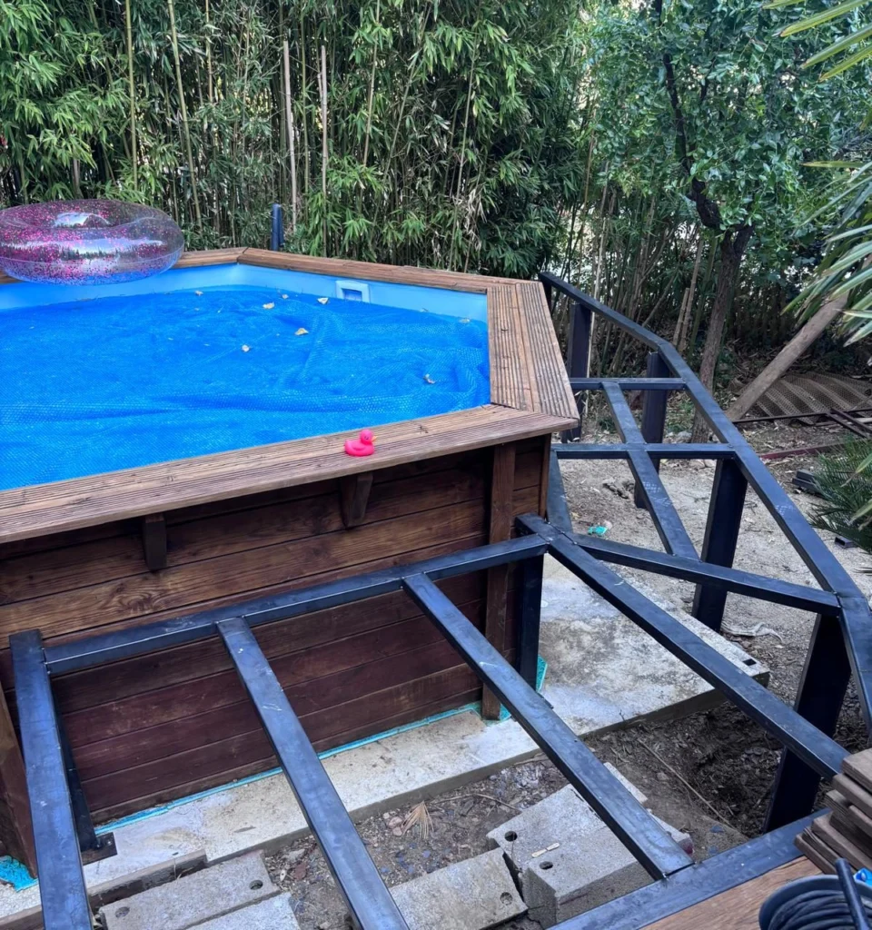 Structure en acier posée autour d’une piscine hors-sol, avant le platelage